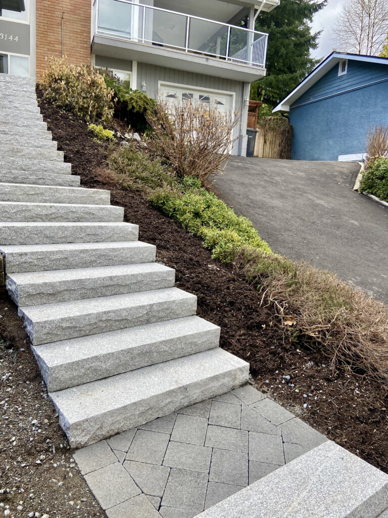 Flamed granite stairs and paver landing by Benjamin Landscaping and Projects.